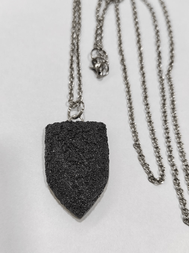 Black textured pendant with chain and leather cord