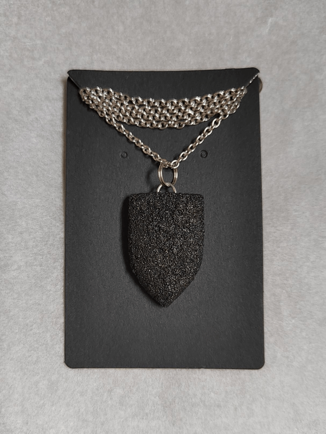 Black textured pendant with chain and leather cord