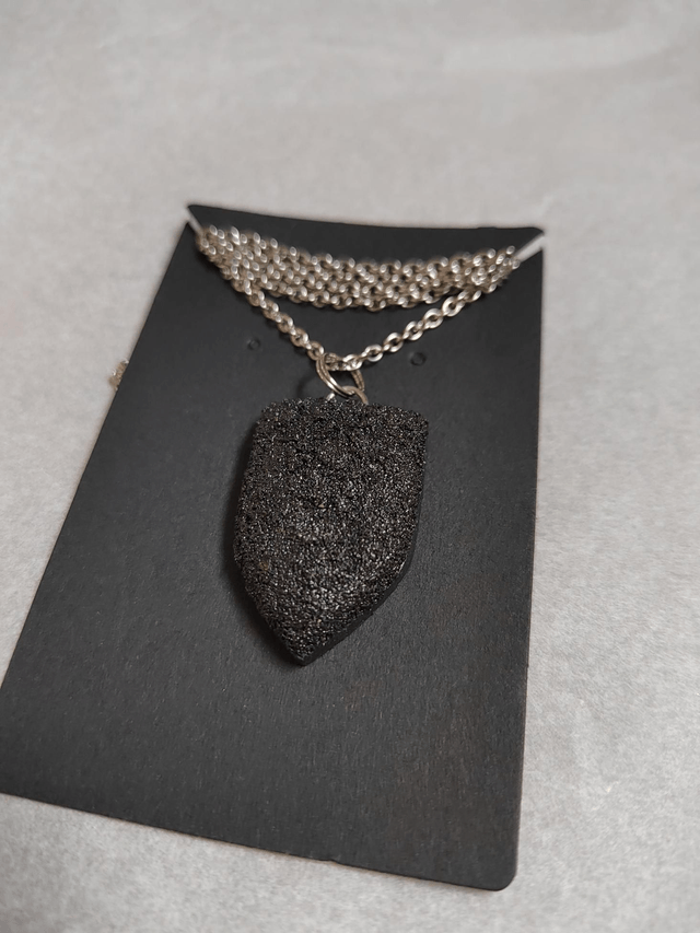 Black textured pendant with chain and leather cord