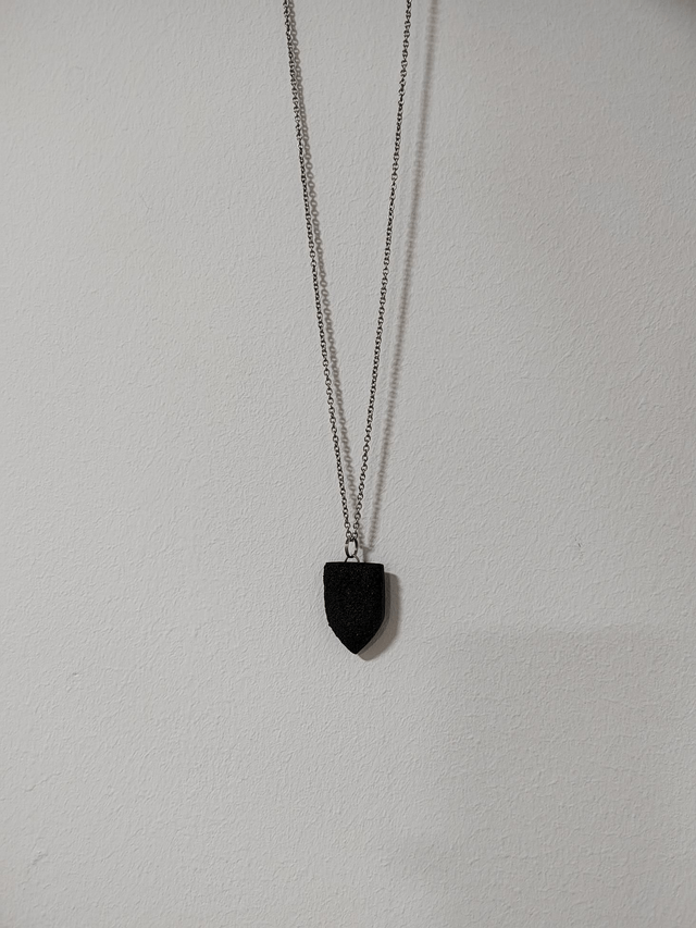 Black textured pendant with chain and leather cord