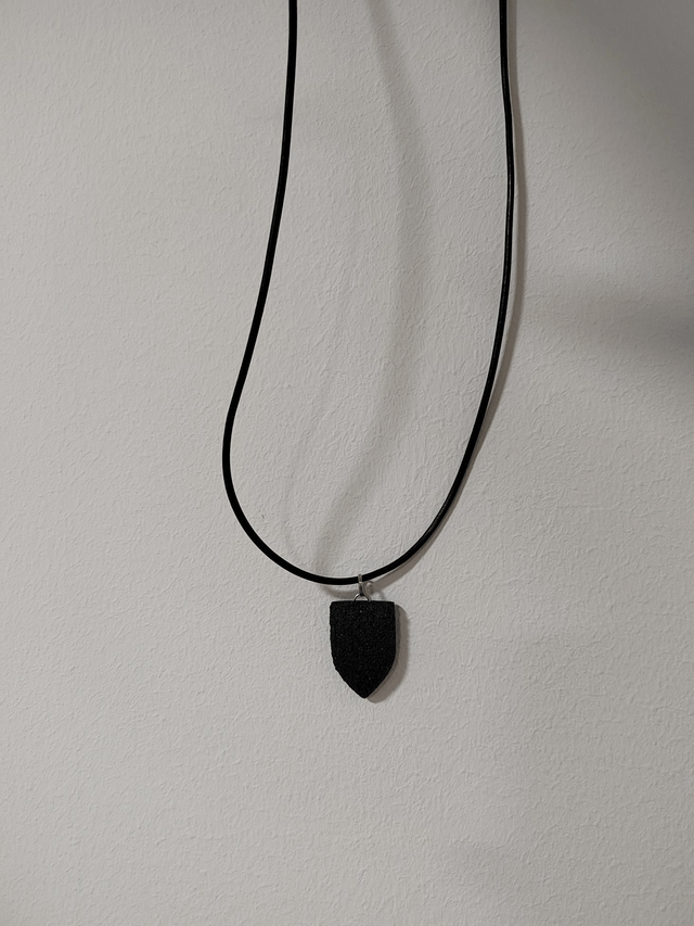 Black textured pendant with chain and leather cord