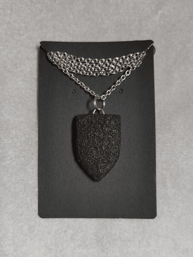 Black textured pendant with chain and leather cord